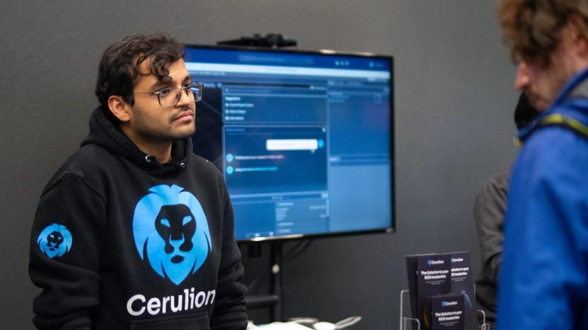 A Cerulion founder in a Cerulion hoodie talks with a visitor at the booth